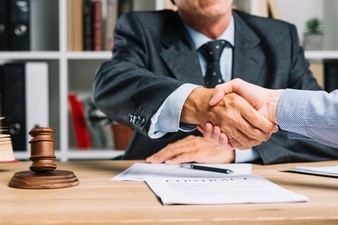 Abogado y su cliente estrechándose la mano sobre el escritorio Foto Premium 